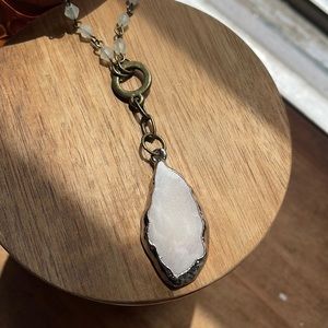Pink rock necklace with white, plastic beads.